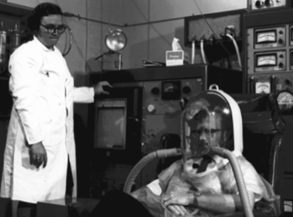 Sujet équipé d'un casque respiratoire expérimental relié à des tuyaux